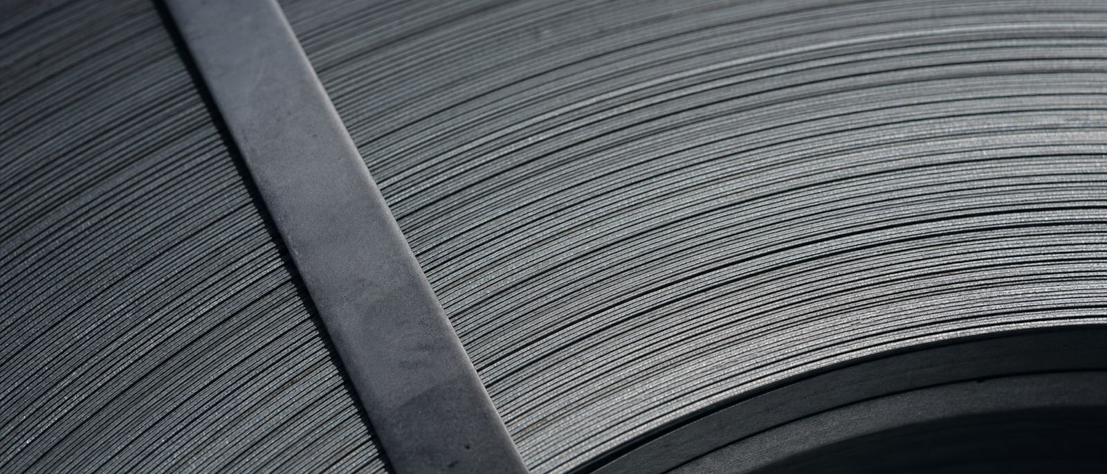 Macro of the wound edge of a steel coil with its banding strap