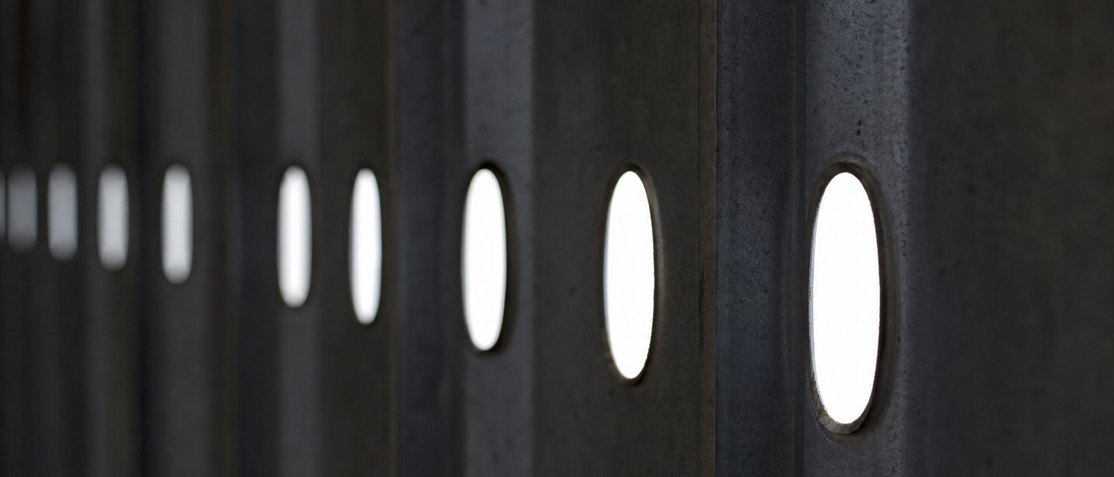 Backlit oval service-hole punchings in a row of cold-formed steel studs