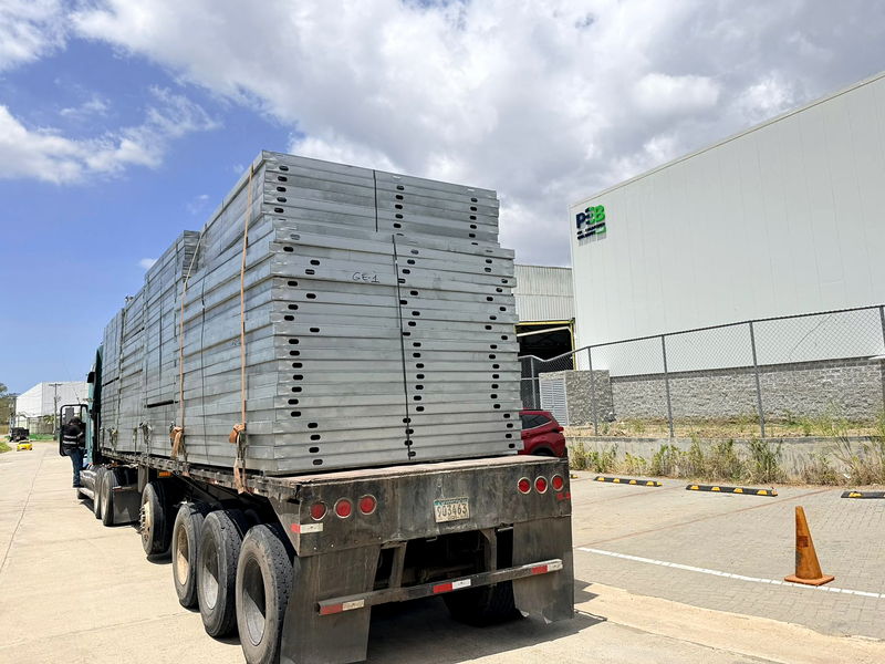 Flatbed truck loaded with punched light-gauge steel panels leaving the manufacturing plant in Panama