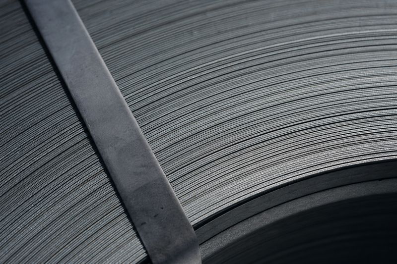 Macro of the wound edge of a steel strip coil, with the banding strap across it