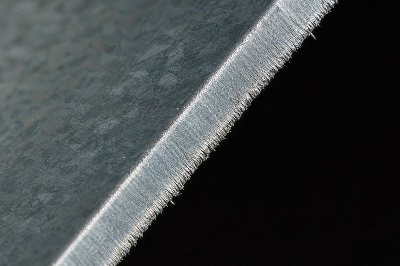 Macro of the cut edge of a Zn-Al-Mg-coated steel sheet, bare steel at the cut face and spangle in the coating
